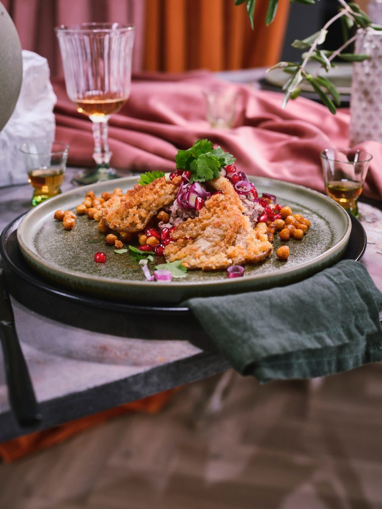 Nahaufnahme von TASTE APPEAL– Rezept: Schwarze Bohnen, Kichererbsen, Austernpilze, Granatapfel, Paranuss auf gedeckten Tisch