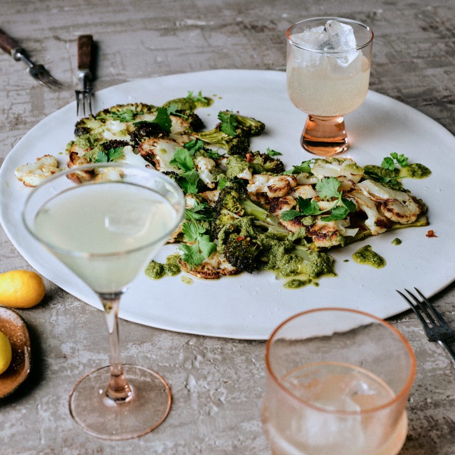 Gegrillter Blumenkohl und Brokkoli mit Kräuterpesto auf Teller mit Getränk - Rezept der Ausgabe querbeet vom Foodmagazin taste appeal–