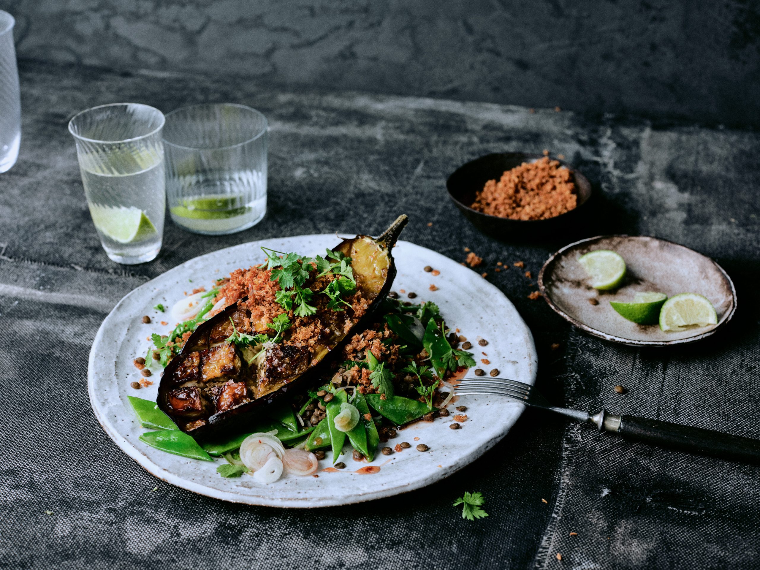 Geschmorte Harissa-Auberginen mit Linsen - Foto von Kräuter-Salat mit Limette auf Teller im Closeup - Rezept der Ausgabe querbeet vom Foodmagazin taste appeal–