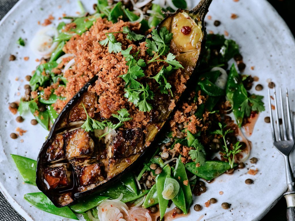 Geschmorte Harissa-Auberginen mit Linsen - Foto von Kräuter-Salat mit Limette auf Teller im Closeup - Rezept der Ausgabe querbeet vom Foodmagazin taste appeal–