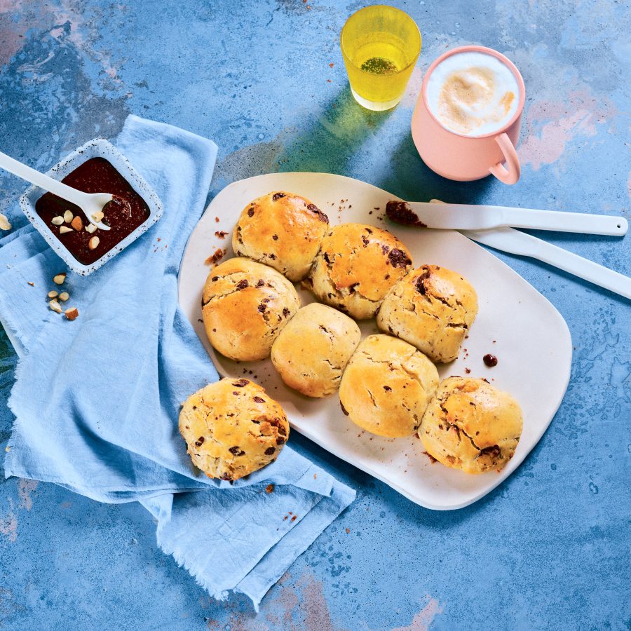 Totale, Vogelperspektive von TASTE APPEAL– Rezept: Schoko-Quarkbrötchen mit Schokonussaufstrich, daneben Besteck, gelbe Gläser und pinke Tasse