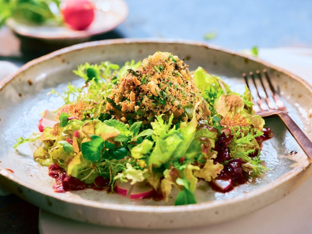 Großaufnahme von TASTE APPEAL– Rezept: Schweinefilet im Kräutermantel mit Schalotten-Rotweinsauce, daneben Gabel