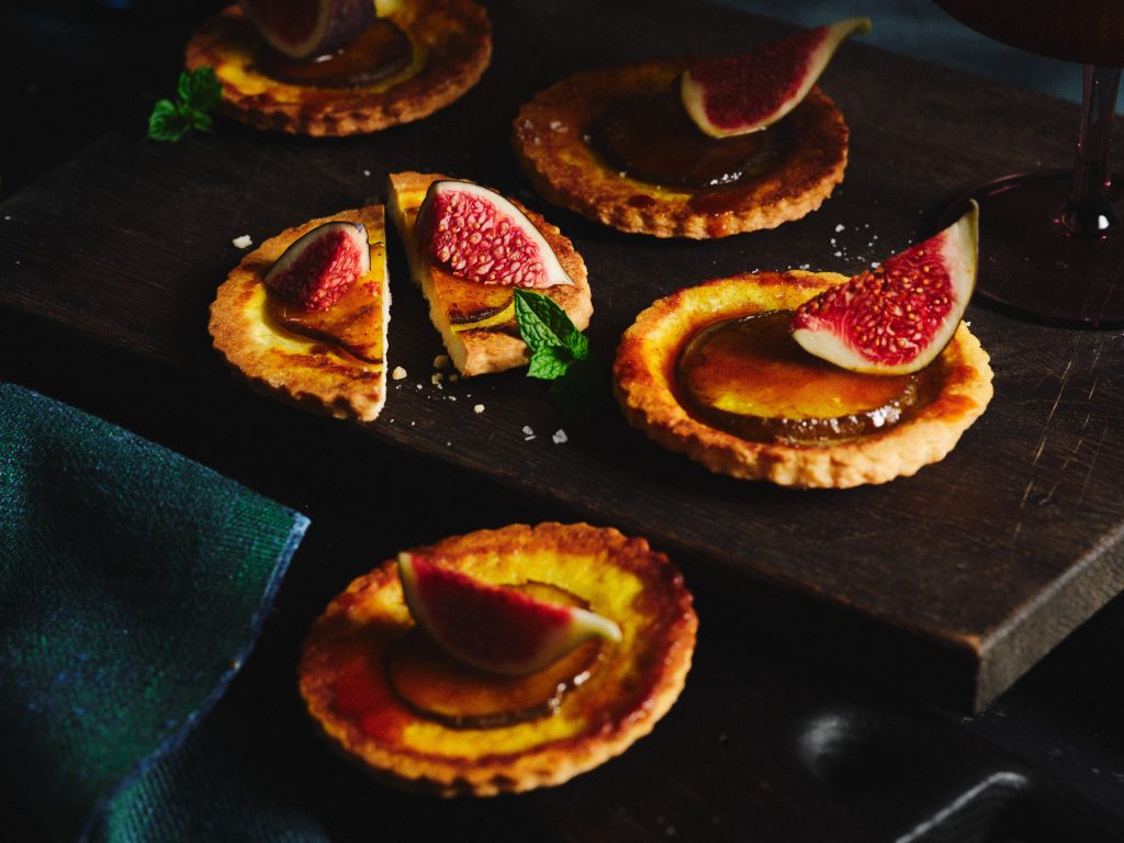 TASTE APPEAL- Rezept Mini-Birnen-Kurkuma-Tarte auf dunklem Holzbrett
